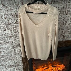 Cream long sweater with pearl detail.